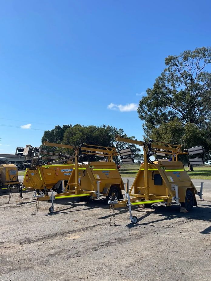 A Row Of Yellow Trailers Are Parked In A Parking Lot — Hybrid Power Australia In Tieri, QLD