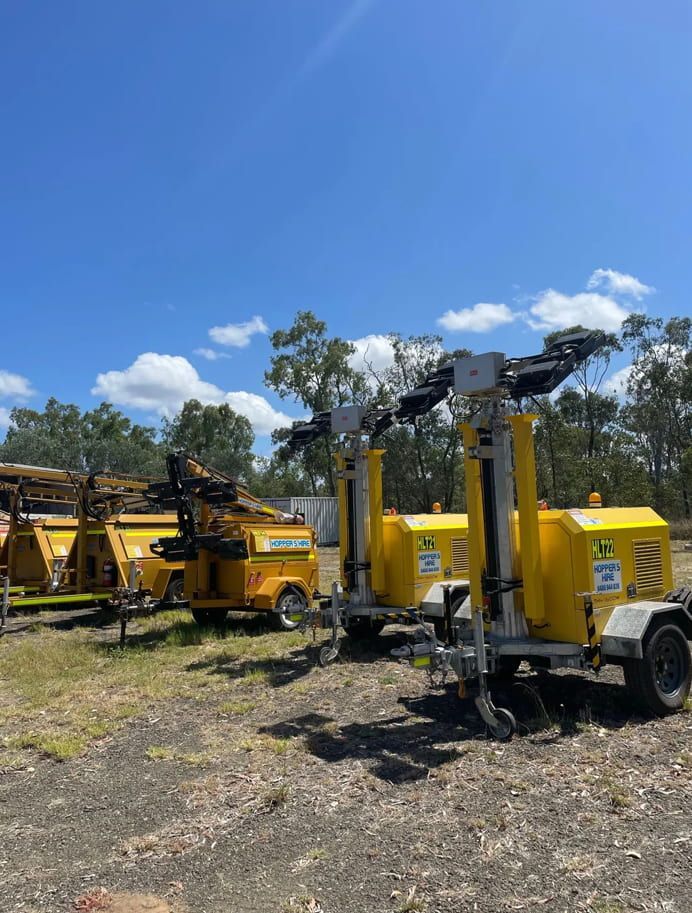 A Row Of Yellow Trucks Are Parked In A Field — Hybrid Power Australia In Emerald, QLD