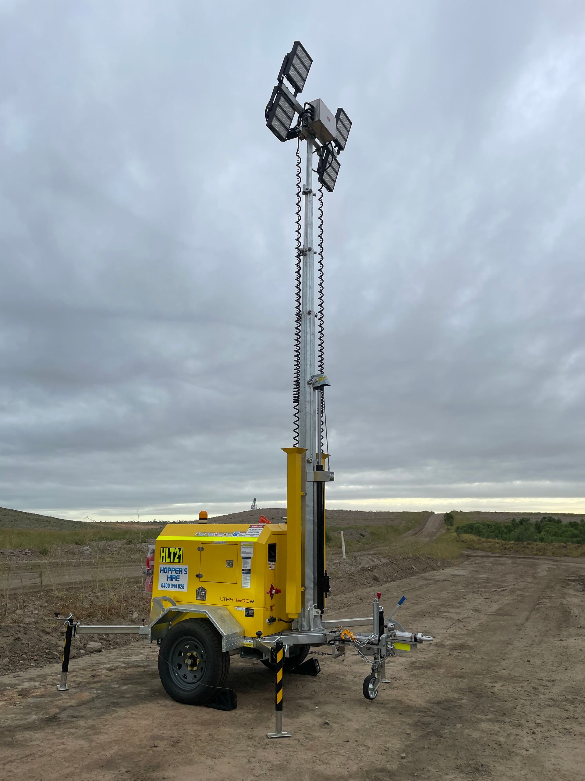 Yellow Mobile Light Tower On A Dirt Road — Hybrid Power Australia in Rockhampton, QLD