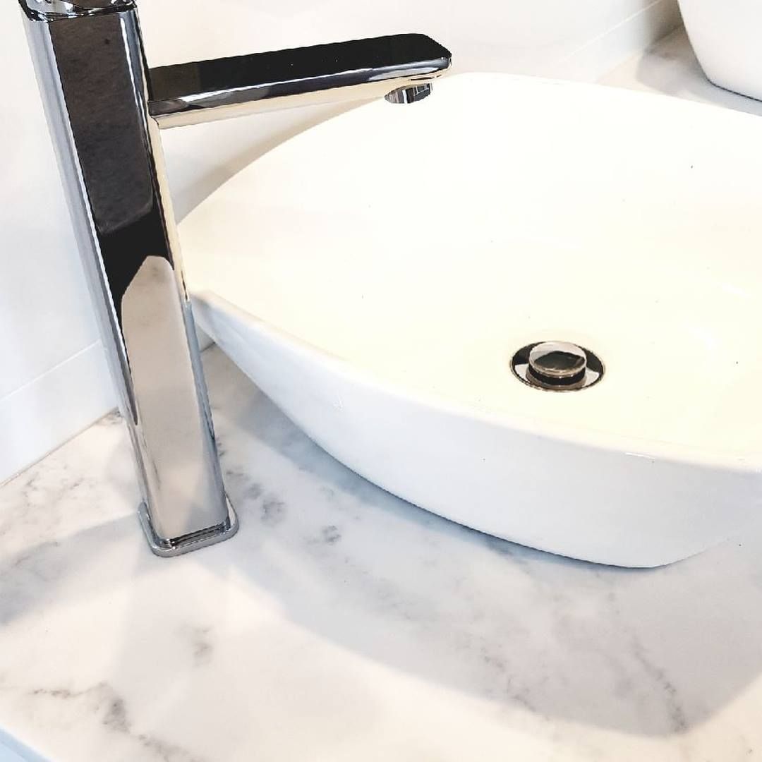 A White Oval Sink and Chrome Faucet on a Marble-patterned Countertop — Corrimal Discount Tiles and Bathroomwear in East Corrimal, NSW