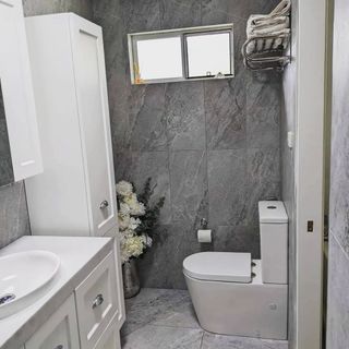 A Modern Bathroom With Gray Tiled Walls, White Toilet, Vanity — Corrimal Discount Tiles and Bathroomwear in East Corrimal, NSW