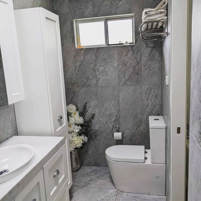 A Modern Bathroom With Gray Tiled Walls, White Toilet, Vanity — Corrimal Discount Tiles and Bathroomwear in East Corrimal, NSW