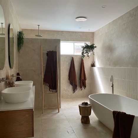 A Bathroom with a Tub, Sinks, Mirrors and a Window — Corrimal Discount Tiles and Bathroomwear in East Corrimal, NSW