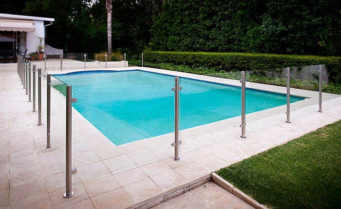 A large swimming pool with a glass fence around it