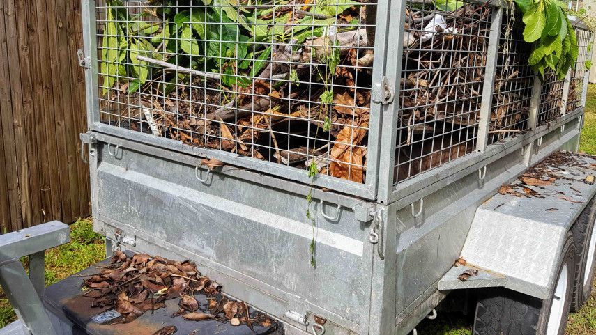 A trailer with a cage full of leaves on it.