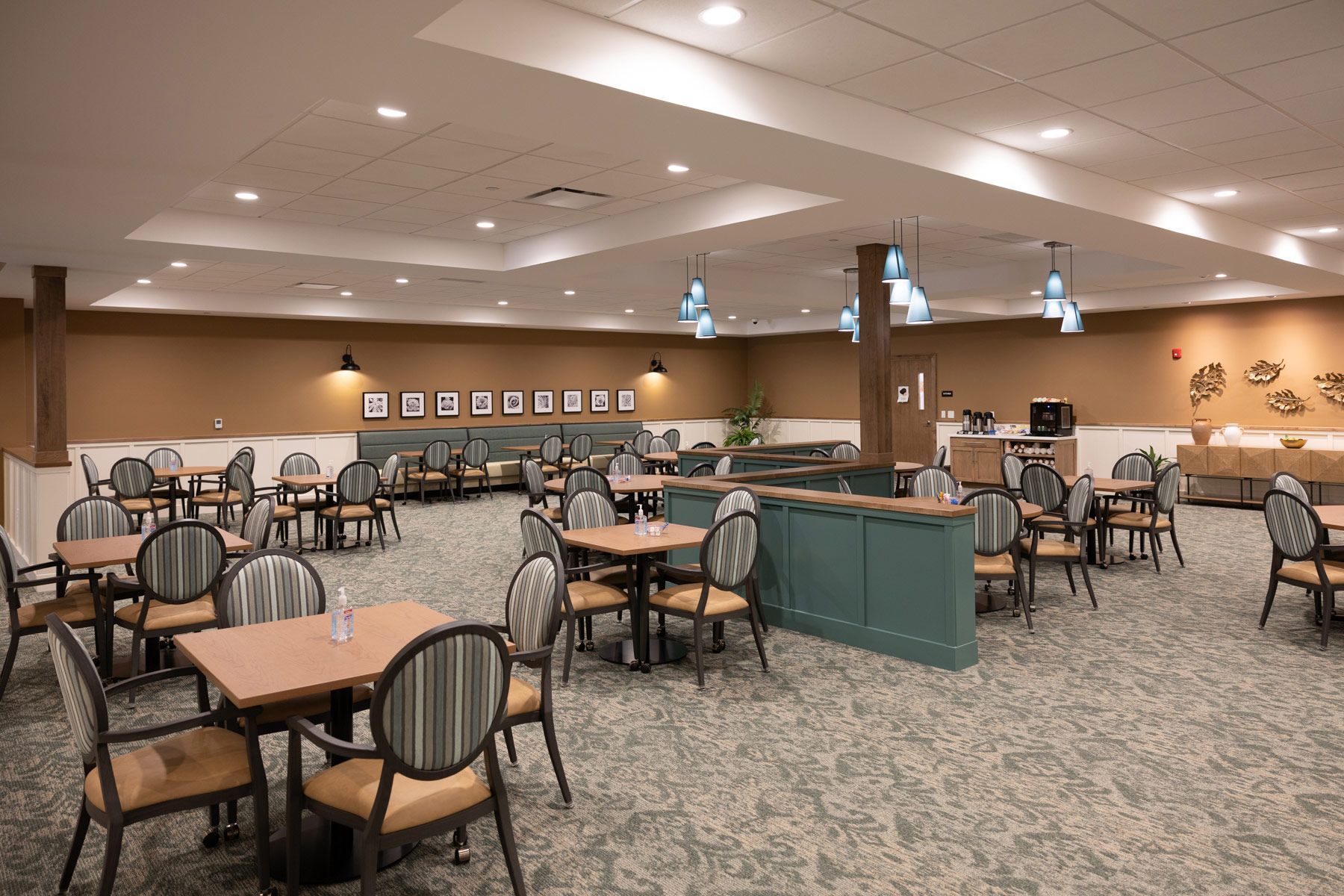 Dining room with tables, chairs, neutral-colored walls, and teal accents.