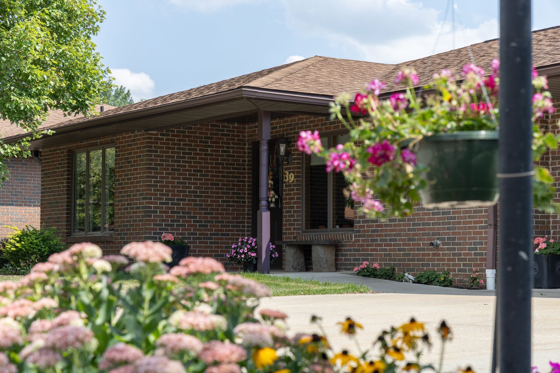 Brick building with hanging flowers in front; sunny day.