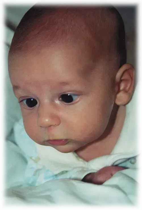 A close up of a baby's face with black eyes.
