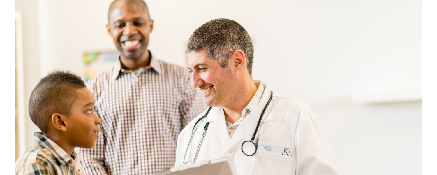 Doctor talking with a child and smiling man in a bright clinic room