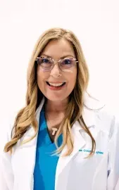 Smiling doctor in a white coat and blue scrubs on a white background