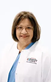 Woman in white medical coat with blue trim, smiling against a plain white background.