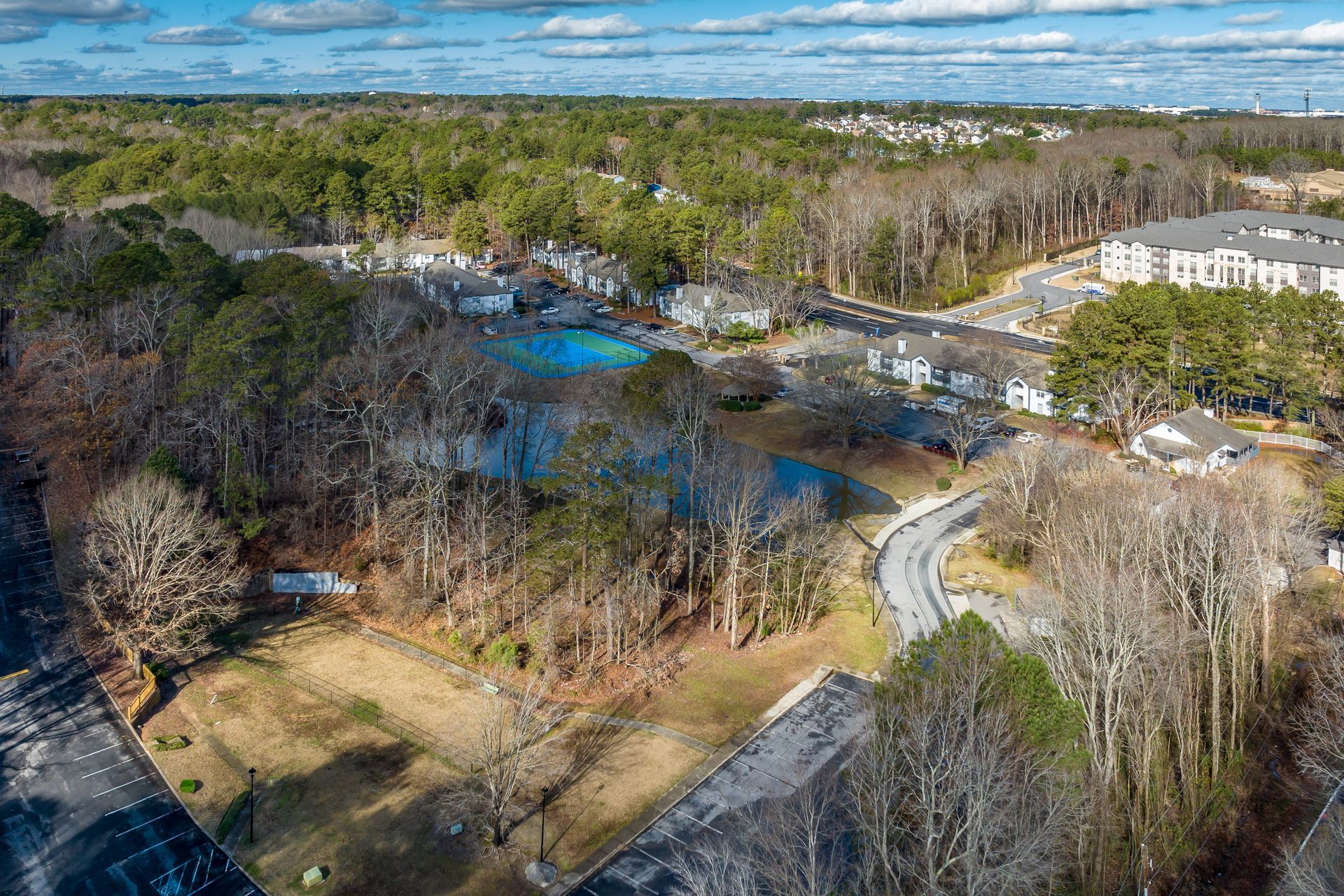 Brick building with white columns, door, and a brick walkway. Green lawn.