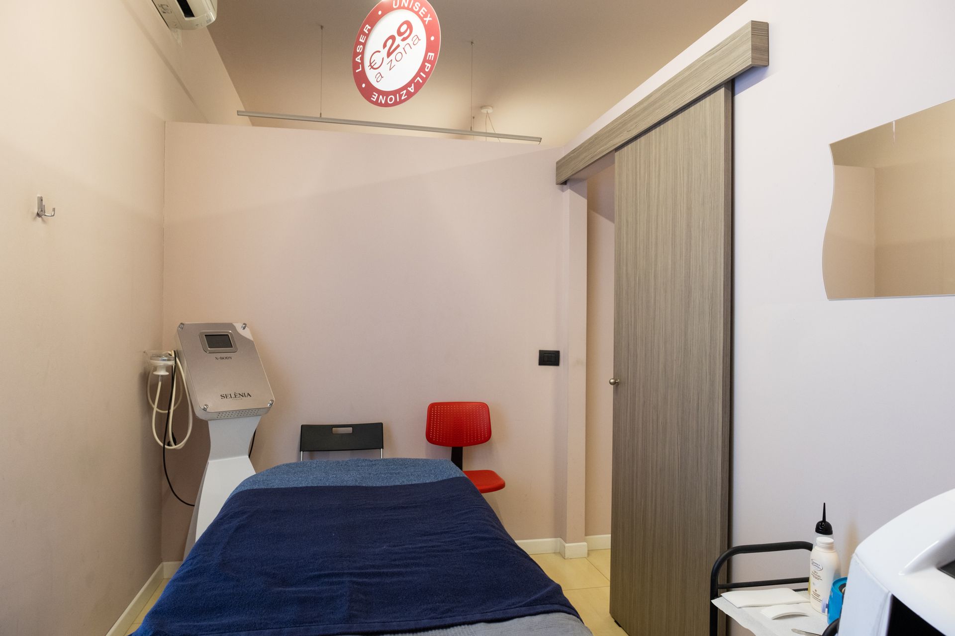 una camera da massaggio con un letto e una sedia .