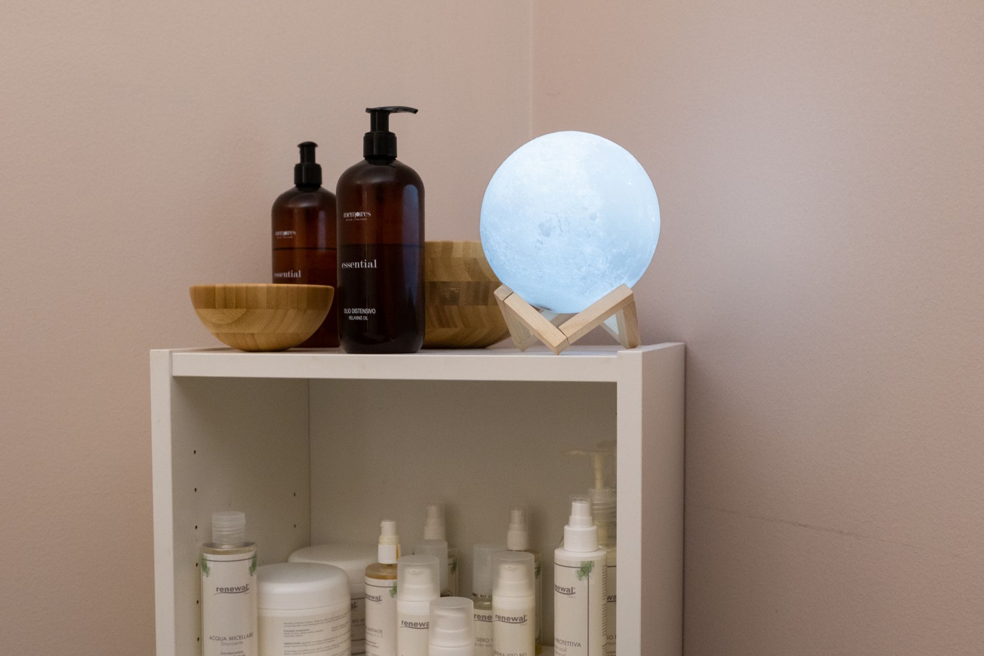 un scaffale pieno di prodotti cosmetici e una lampada a forma di luna .