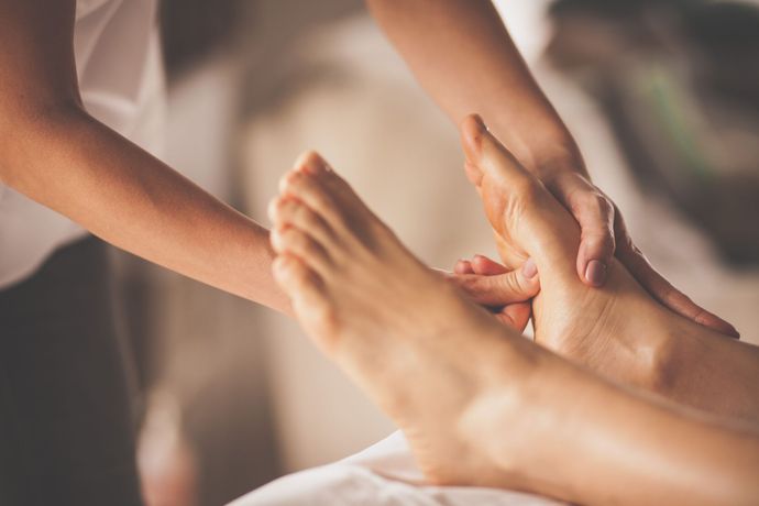 una donna sta ricevendo un massaggio ai piedi da un massaggiatore .