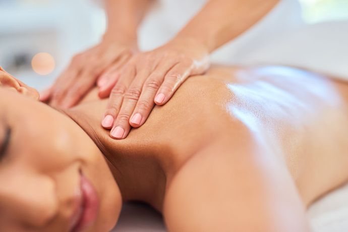 una donna sta ricevendo un massaggio al collo in un salone di bellezza .