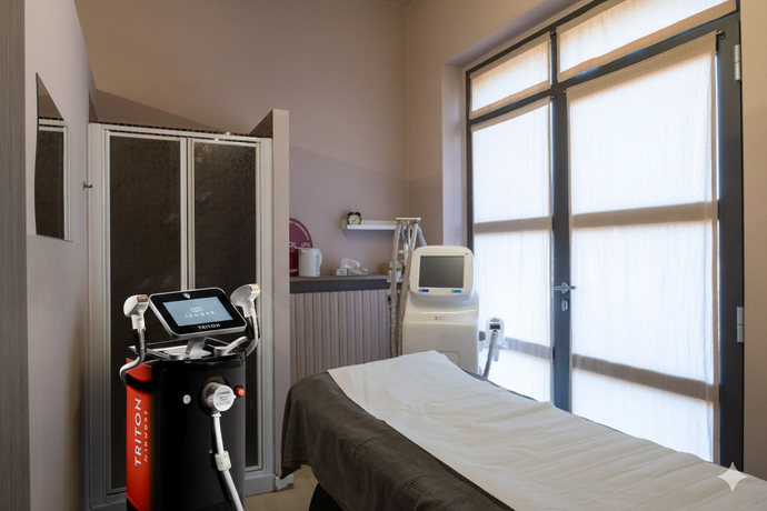 Sala per trattamenti spa con letto, attrezzature e finestra.