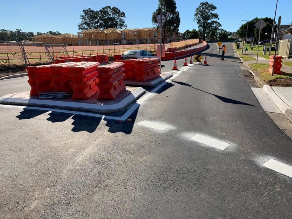 A road with a lot of orange barriers on it