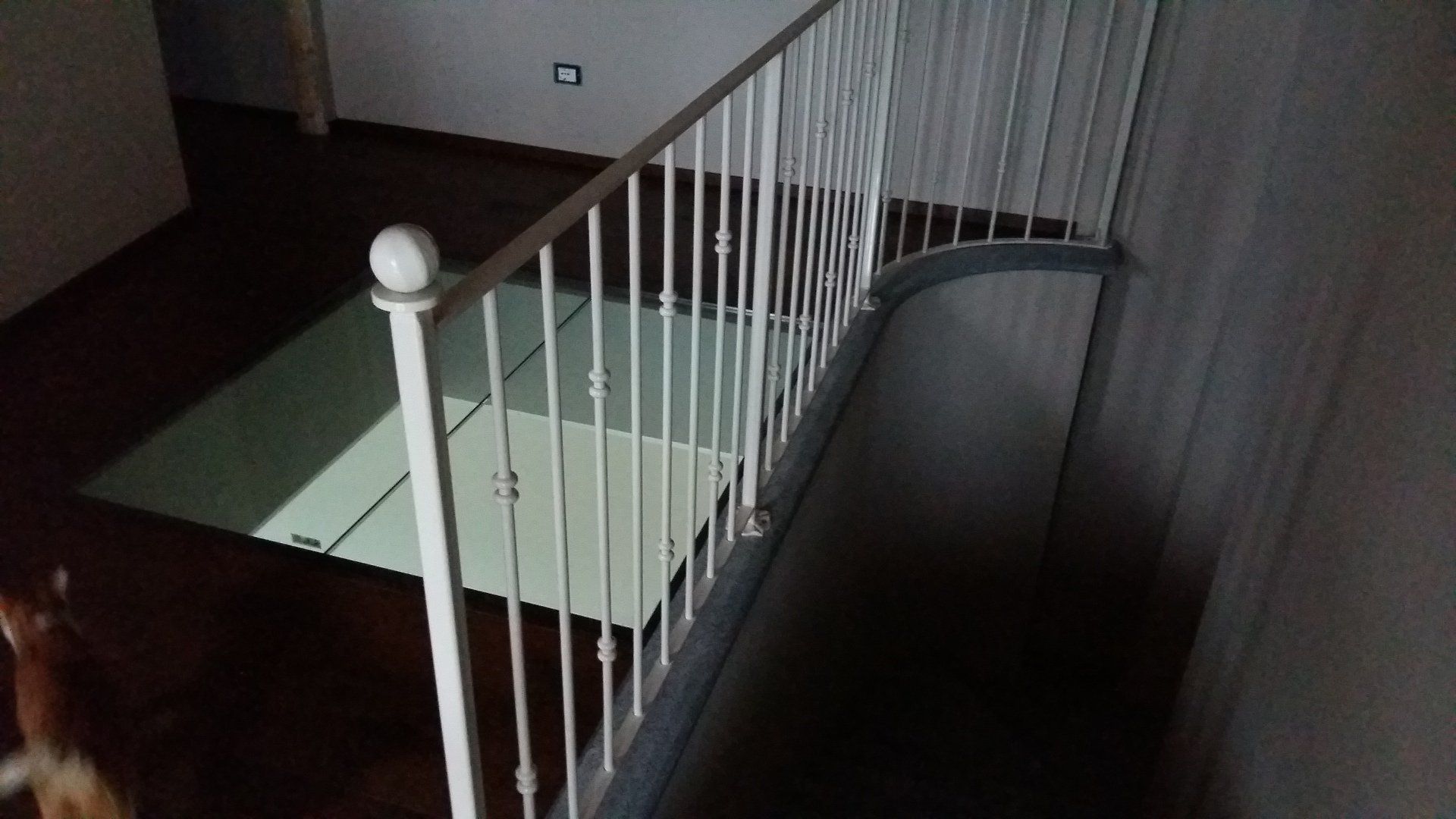 Una scala con ringhiera bianca e pavimento in vetro.