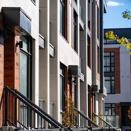 A row of apartment buildings with stairs leading up to them