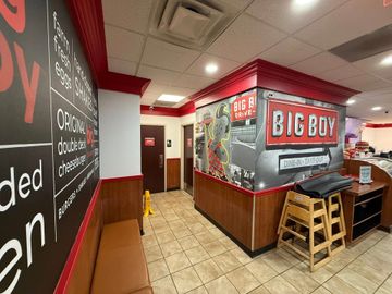 A hallway in a restaurant with a big boy sign on the wall.