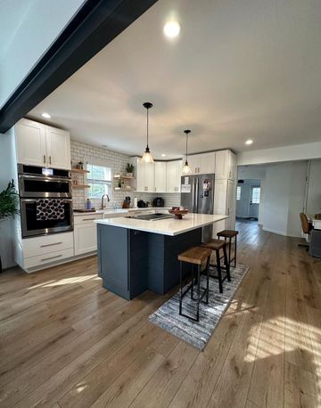 A kitchen with a large island and stools in it