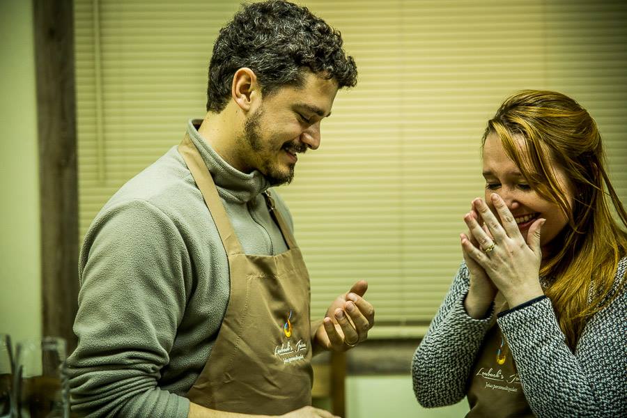 Um homem e uma mulher riem juntos em uma cozinha.