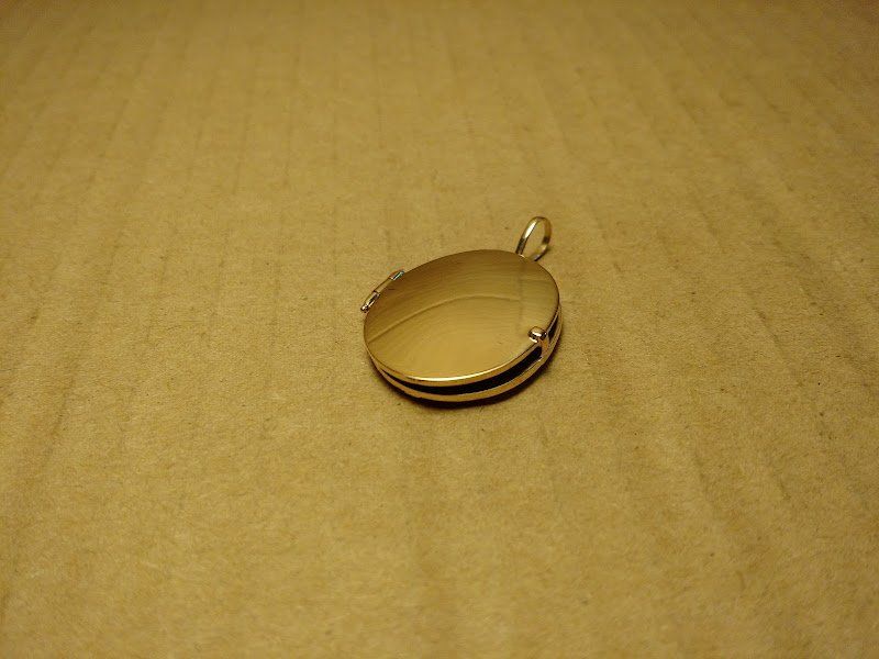 Um medalhão de ouro está colocado sobre uma superfície marrom