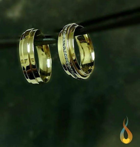 Um par de alianças de ouro penduradas em uma barra de metal