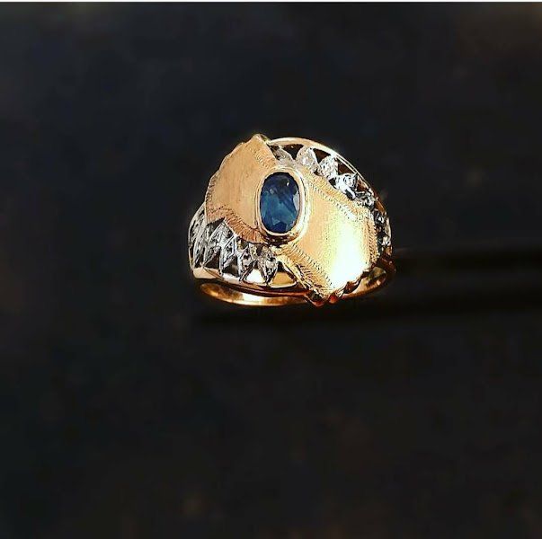 Um anel de ouro com uma pedra azul no centro