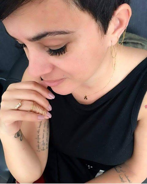 Uma mulher usando um colar com a letra a