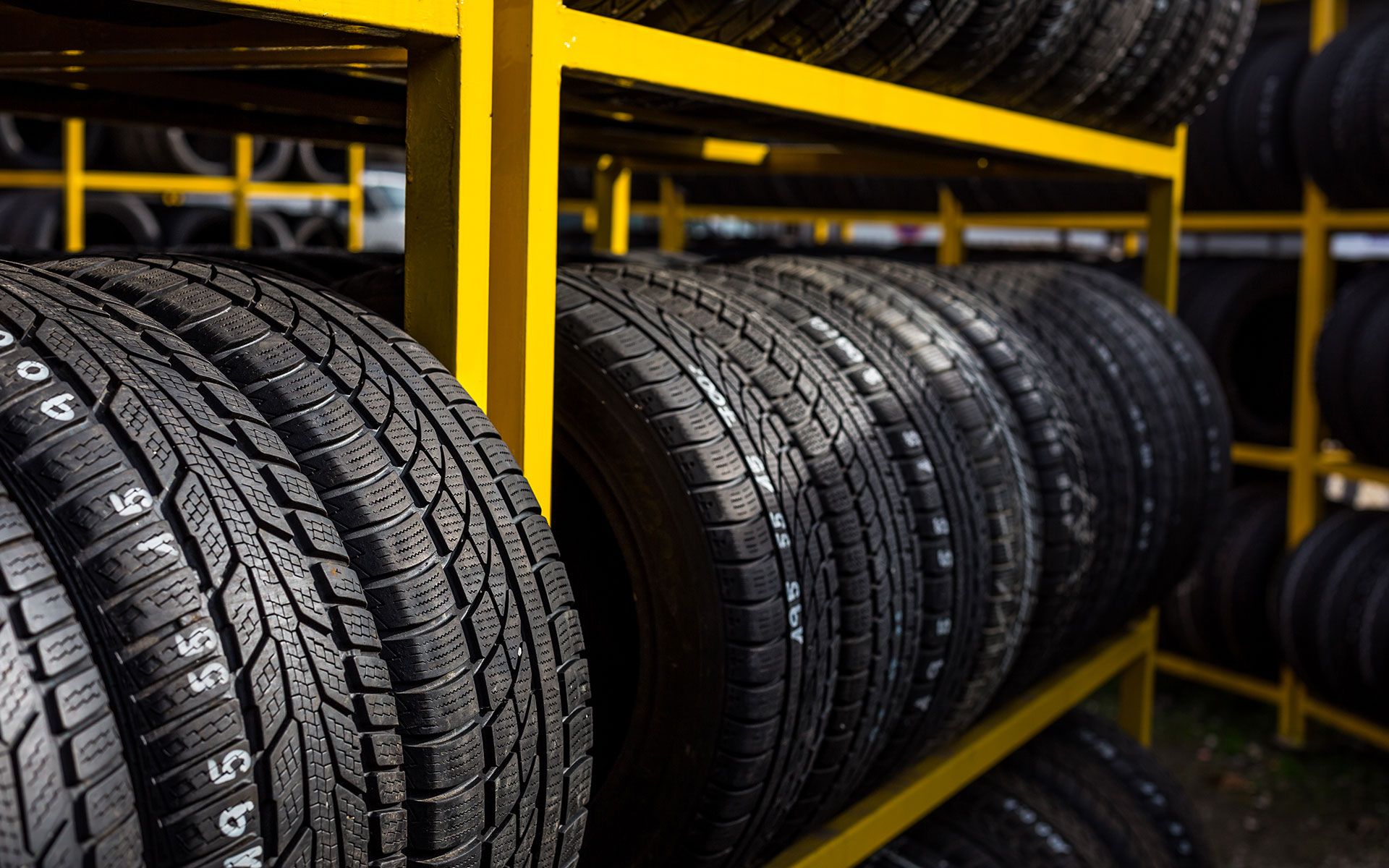 A bunch of tires are stacked on top of each other on a shelf.