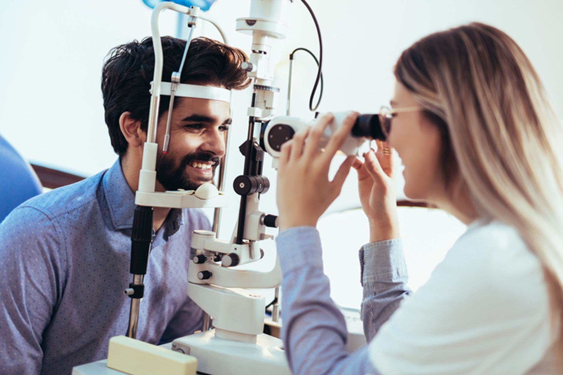 A person and person looking through a microscope