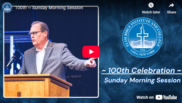 Man speaking at a lectern during the 100th-anniversary celebration of the Elim Bible Institute & College. 