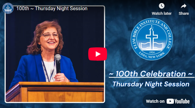 Woman speaking at a lectern, smiling, during a 100th-anniversary celebration of Elim Bible College