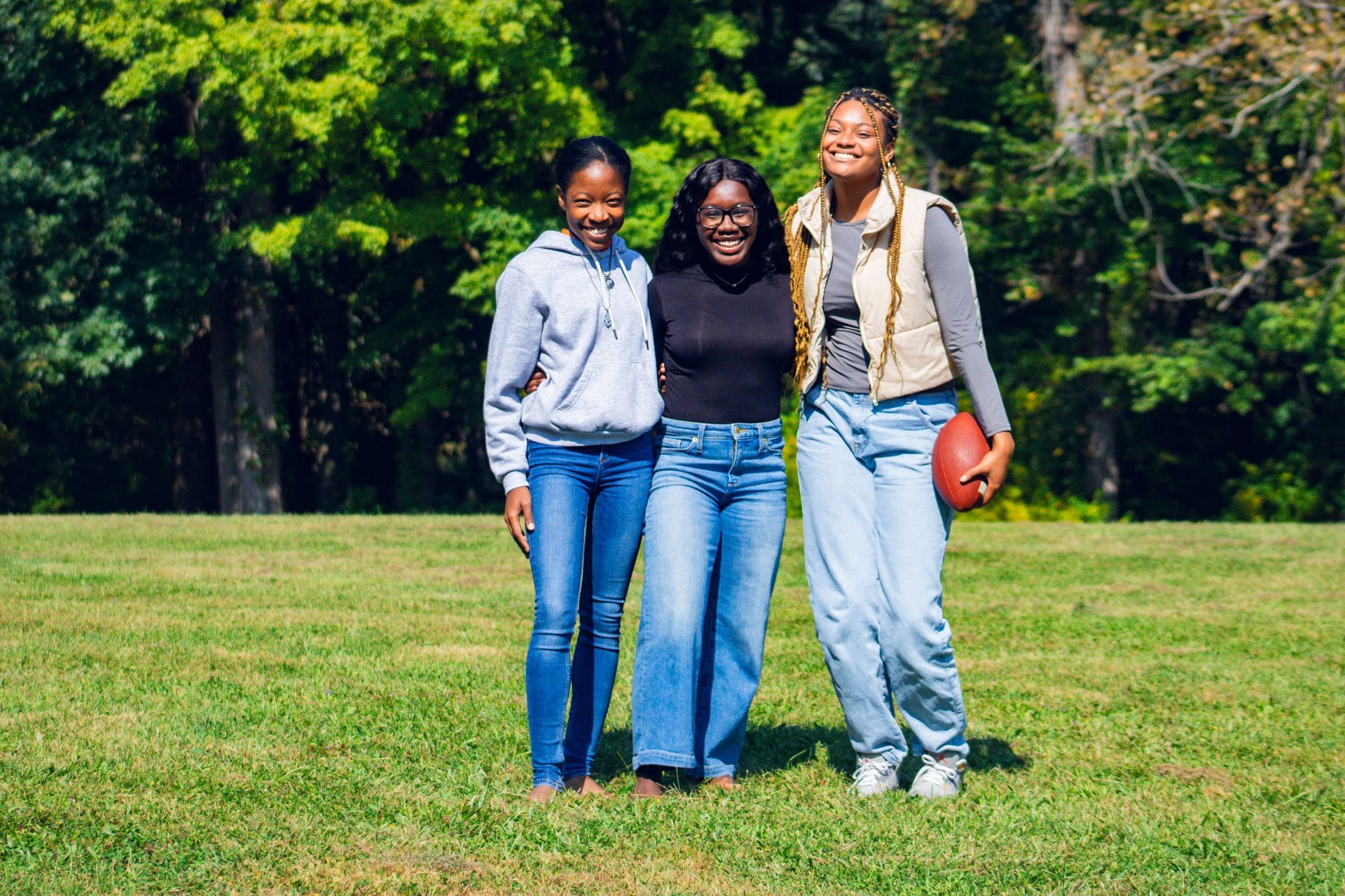 Three women stand together smiling