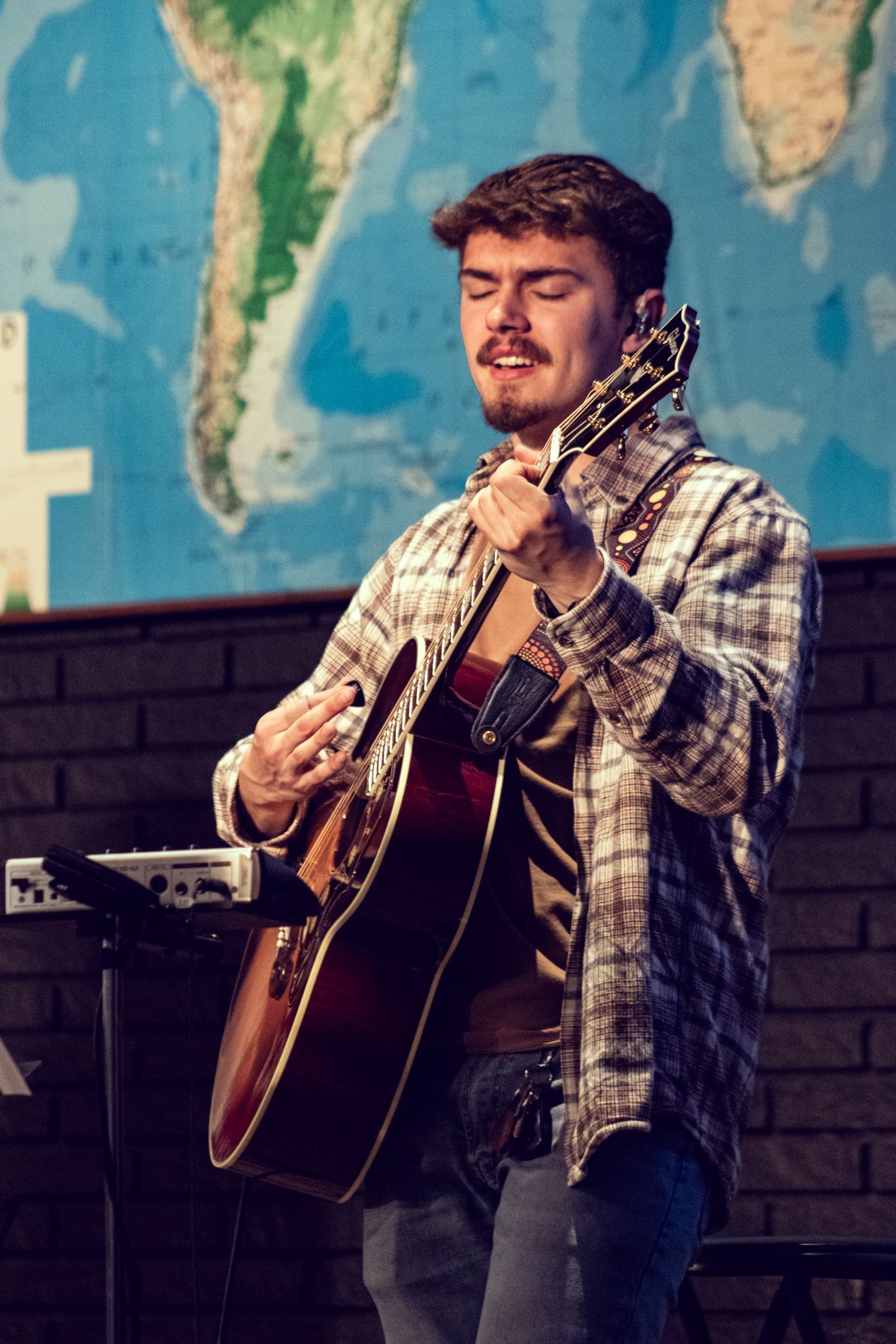 A man is playing a guitar during a chapel service