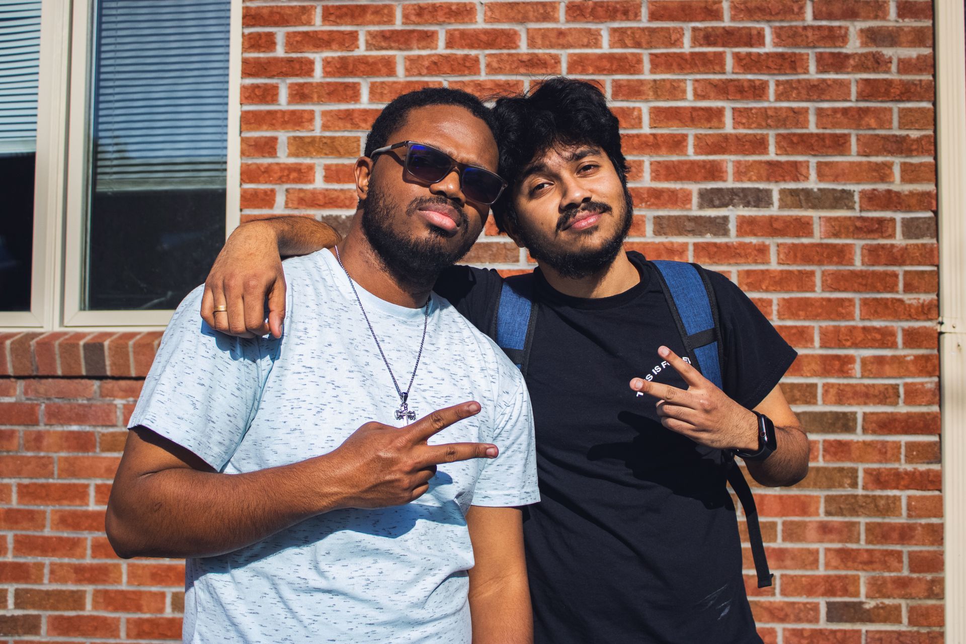 two students standing in front of brick building
