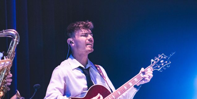 A student plays guitar during worship