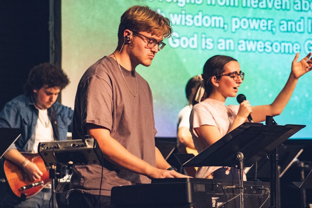 a group of students leading worship together 