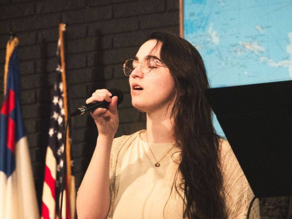 a student leading worship during chapel