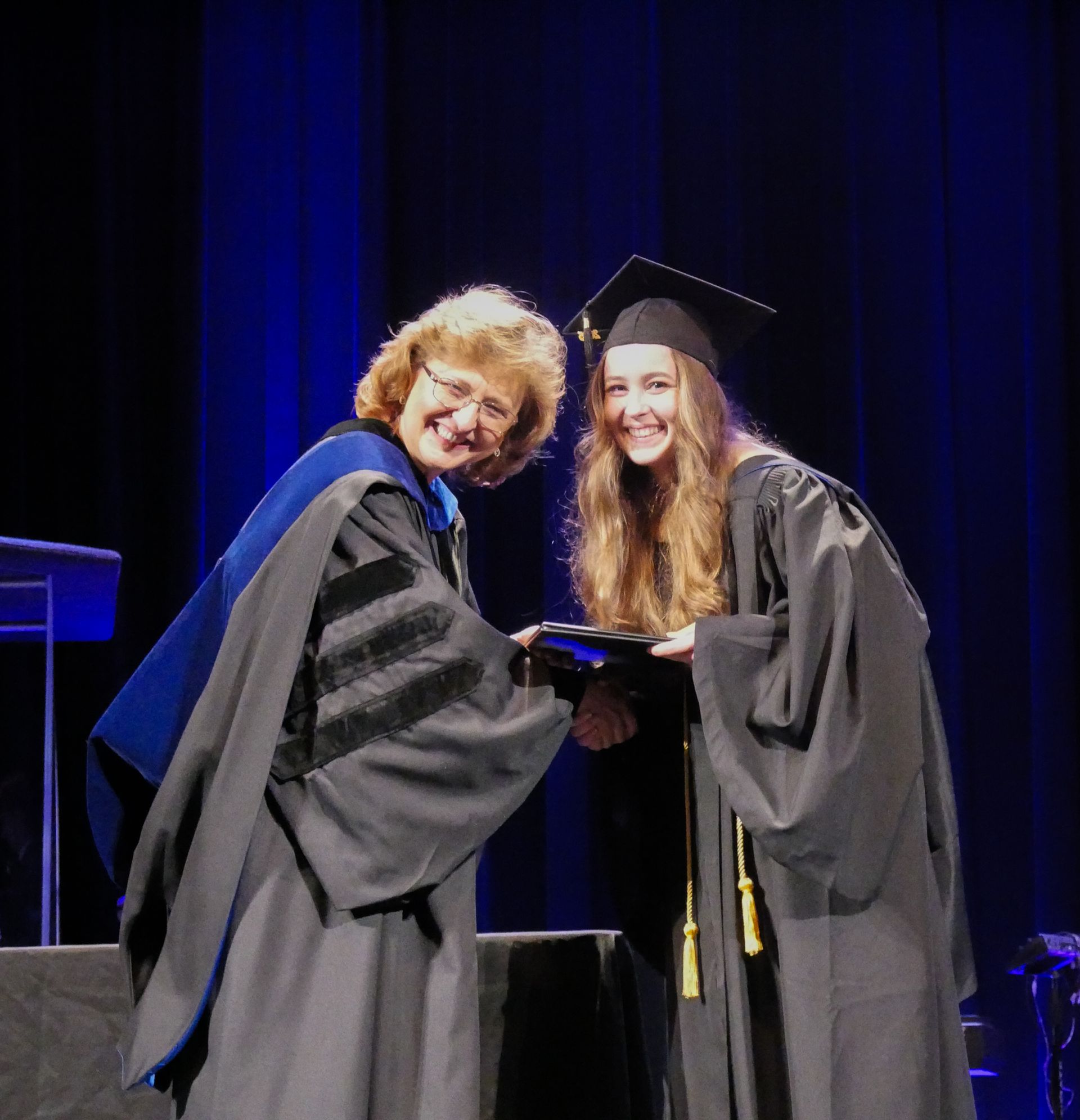 A female student receives her degree during commencement
