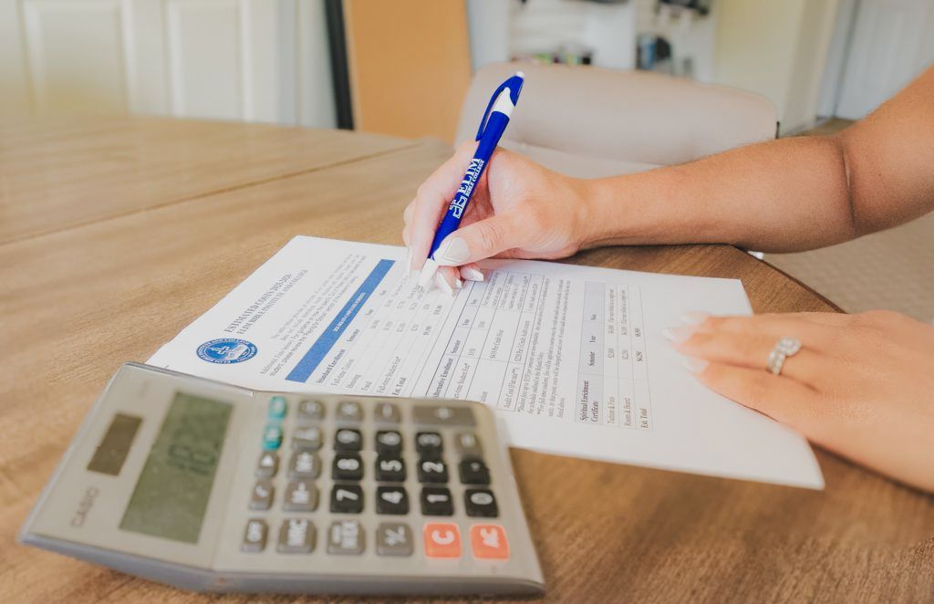 a woman filling out Elim paperwork with a calculator