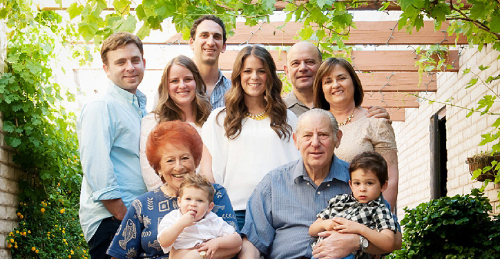 A family with grandparents sitting together outside