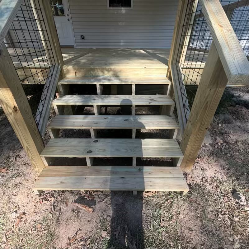 A wooden deck with stairs leading up to a house.