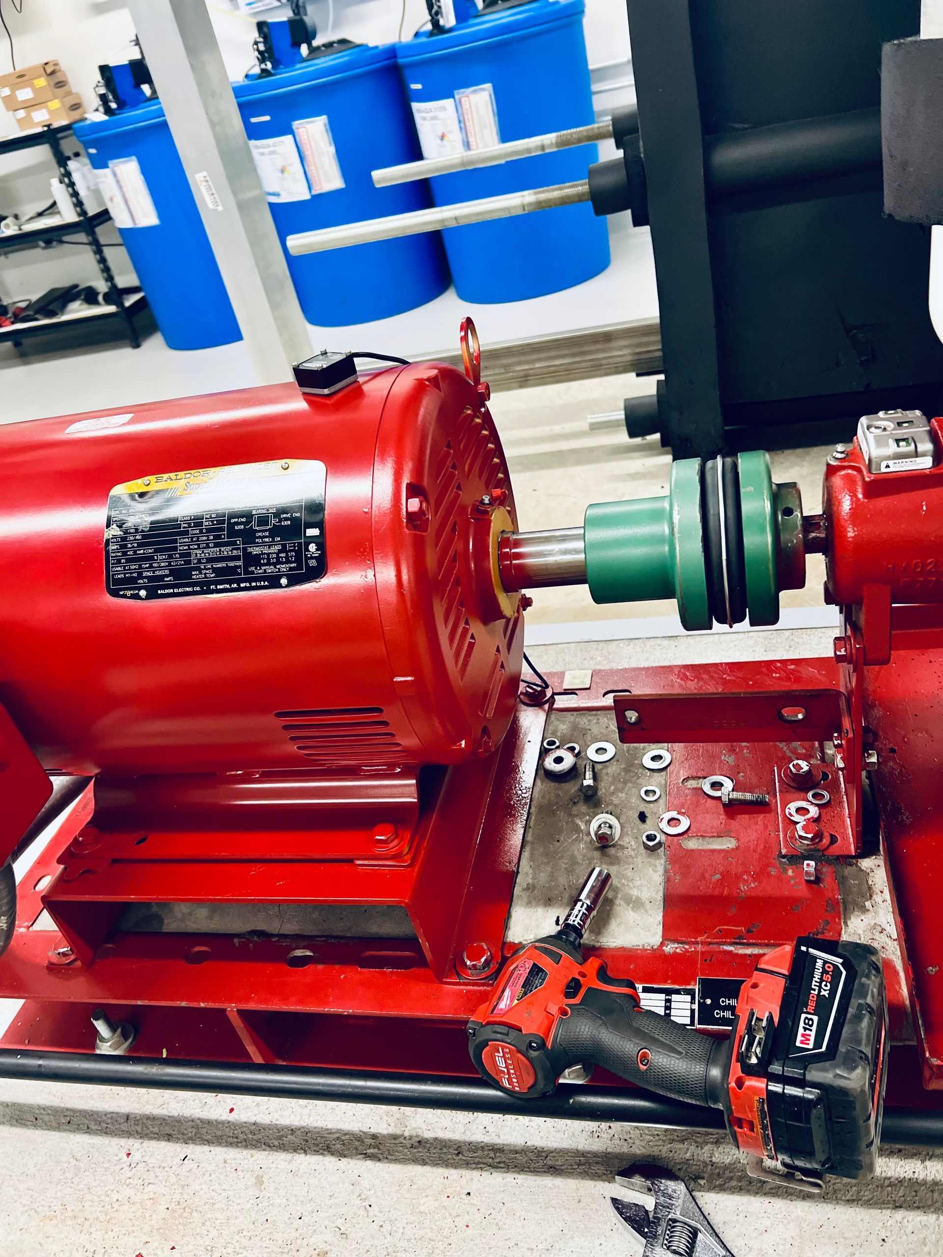 A red motor is sitting on a table next to a drill