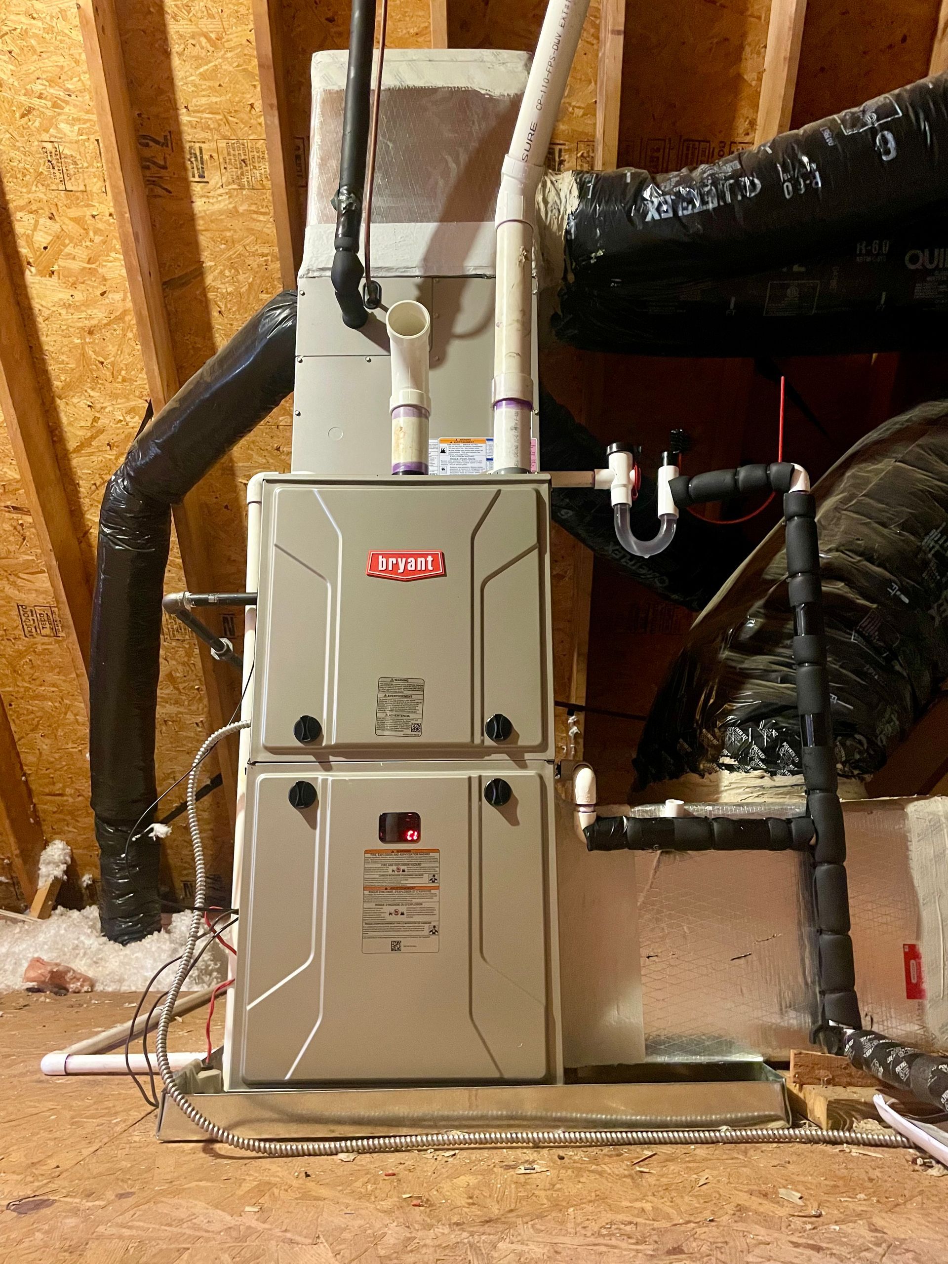 A furnace is sitting in the attic of a house.