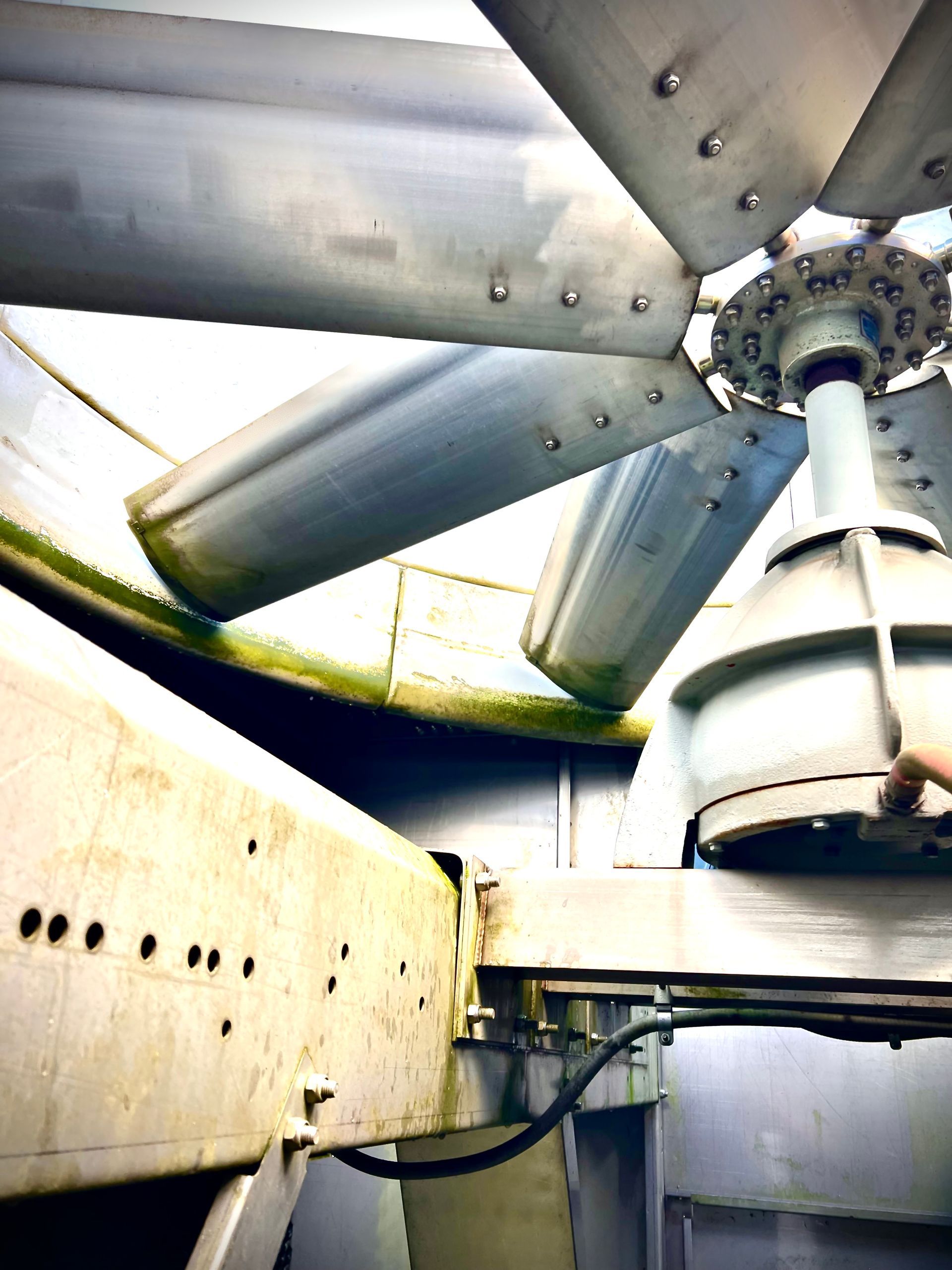 A close up of a large metal fan on top of a building