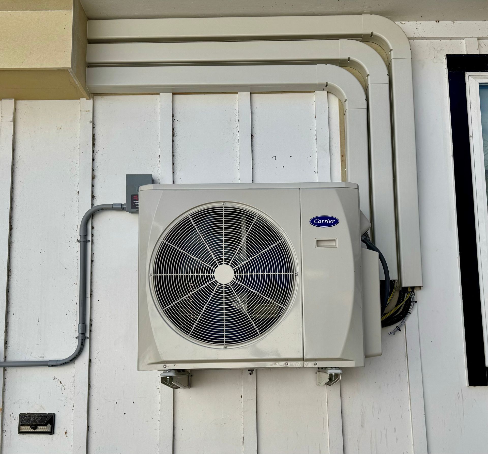 A carrier air conditioner is mounted on the side of a building