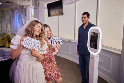 A man and two women are posing for a picture in a photo booth.